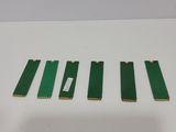 four pieces of green plastic are sitting on a white surface