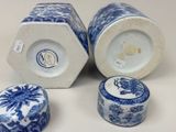 three blue and white vases with lids sitting on a white surface