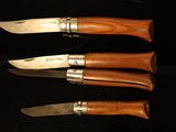 three knives that are sitting on a black surface