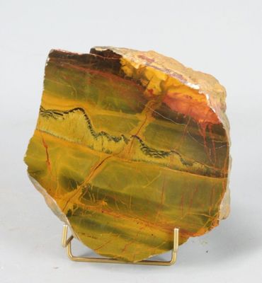 une photo d'un morceau de marbre jaune et vert posé sur un socle en métal