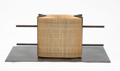 une petite boîte en bois munie d'une poignée, posée sur un socle en métal