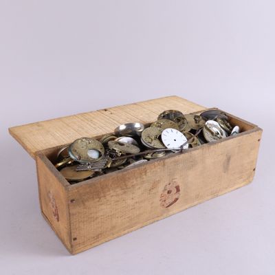 une boîte en bois remplie de pièces de monnaie posée sur une surface blanche