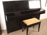 a black piano and a stool in the corner of a room