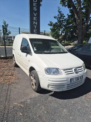une camionnette blanche garée sur un parking à côté d'une voiture noire