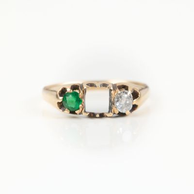 a close up view of a three stone ring with a green and white stone