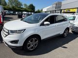 Une Ford Edge blanche est garée sur un parking avec d'autres voitures