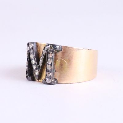 an image of a gold and silver ring with the letter m