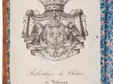 a hand holding a book with a drawing of a coat of arms on it