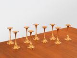 six gold candlesticks sitting on a wooden table