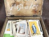 une boîte en bois remplie de cartes religieuses et un tableau noir sur lequel sont écrites des inscriptions