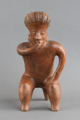 une petite figurine représentant un homme coiffé d'un chapeau
