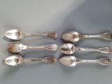 six silver spoons sitting on top of a table next to each other