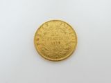 a close up of a gold coin on a white surface