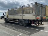 a truck that is driving down the street in the day