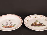 two plates with animals on them sitting on a black surface