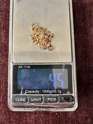 a gold chain on top of a scale on a red cloth