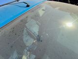 a reflection of a person in the windshield of a car