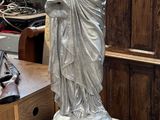 a statue of a woman holding a bird on top of a pedestal