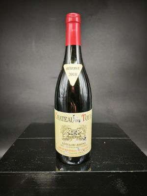 La bouteille de vin rouge est posée sur une table noire.