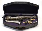 un saxophone dans son étui, posé sur une surface blanche