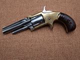 an old revolver with a wooden handle on a brown surface