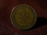 a close up of a coin sitting on top of a brown leather surface