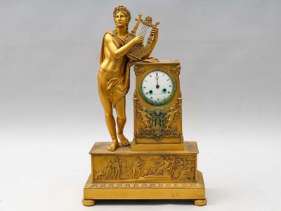une statue en or représentant une femme tenant une harpe et une horloge