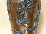 a brown vase with a blue design on it