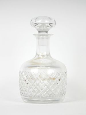 crystal decanter with stopper on top on a white background