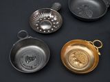 five different types of frying pans on a black surface