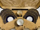 a suitcase with a set of cups and saucers in it