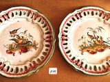 two plates with birds painted on them on a table