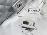 a white purse with a drawing of a woman ' s face on it