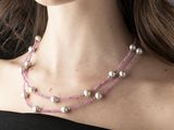 a woman that is wearing a necklace with pearls on it