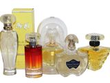 plusieurs flacons de parfum différents et une boîte de parfum posés sur une surface blanche