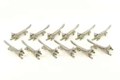 un gros plan sur un groupe de petites girafes en métal posées sur une surface blanche