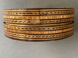 four wooden bang bracelets stacked on top of each other on a gray surface