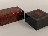 deux petites boîtes en bois ornées de motifs, posées sur une table