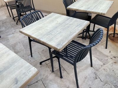 de nombreuses tables et chaises installées dehors, sur la terrasse