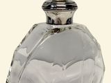 a clear glass bottle with a silver top on a white surface