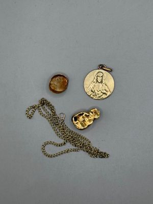 trois bijoux, dont une pièce de monnaie, un collier et un pendentif