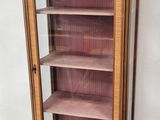 une grande armoire en bois avec des étagères, placée dans un coin de la pièce
