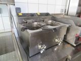 une cuisine avec de nombreux appareils électroménagers en inox posés sur le plan de travail