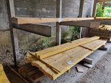 Plusieurs morceaux de bois sont empilés sur une palette à l'intérieur d'un bâtiment