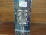 une brosse à cheveux dans une boîte transparente posée sur une table en bois
