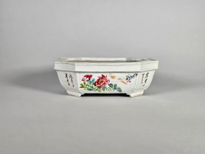 un bol blanc orné de fleurs, posé sur une table