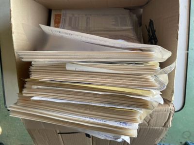 une boîte en carton remplie de papiers, posée sur une table