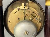 a clock that is sitting on a stand on the table