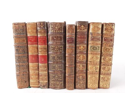 several old books are lined up in a row on a white surface