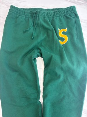 a pair of green sweat pants with the letter s on them